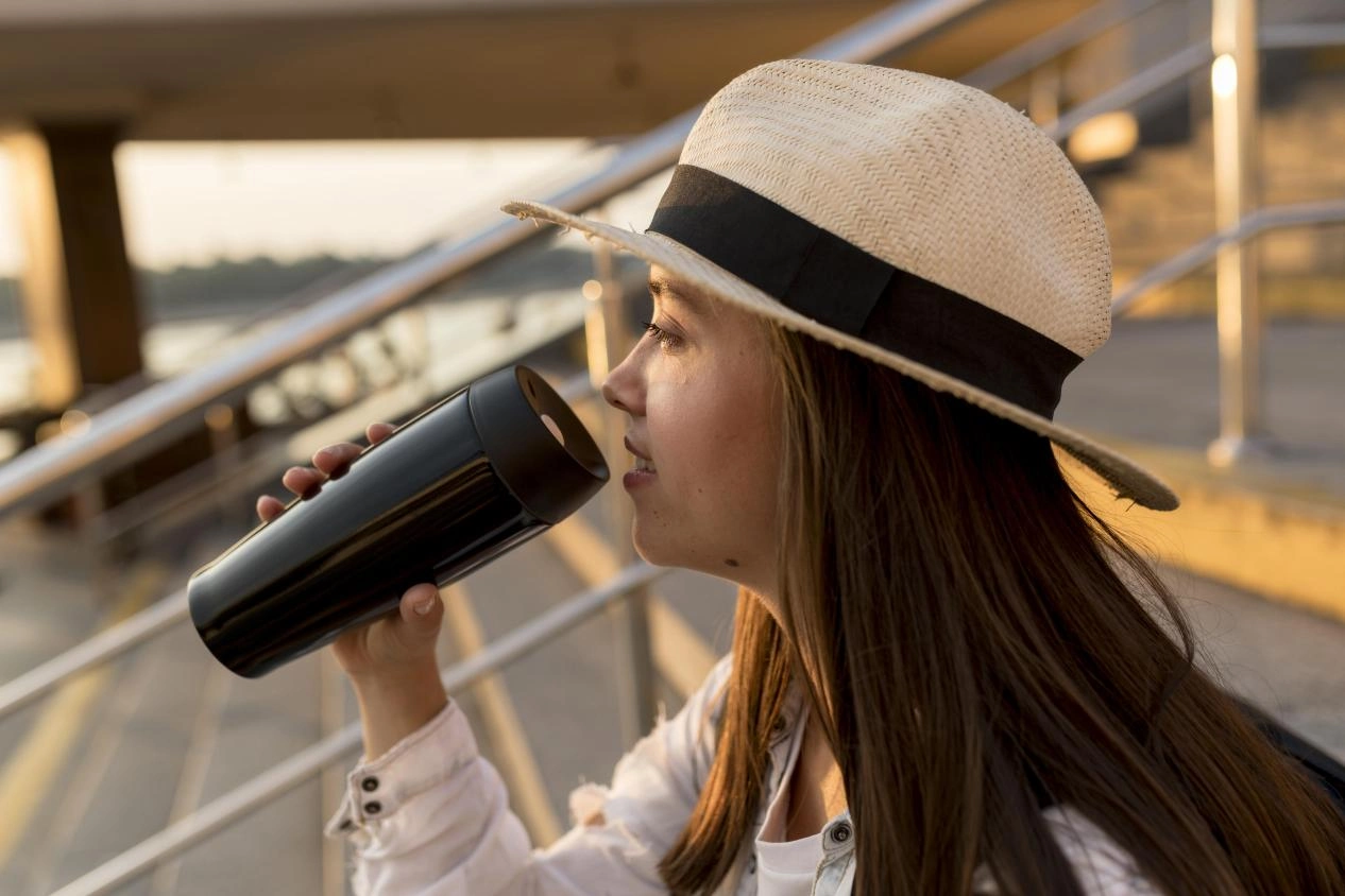 a woman drinking water with her Insulated Water Bottle